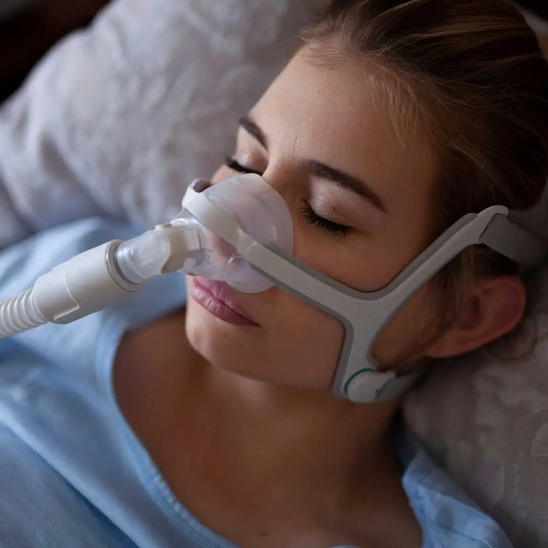 CPAP machine setup on bedside table, showing a common treatment for sleep apnea during nighttime sleep.