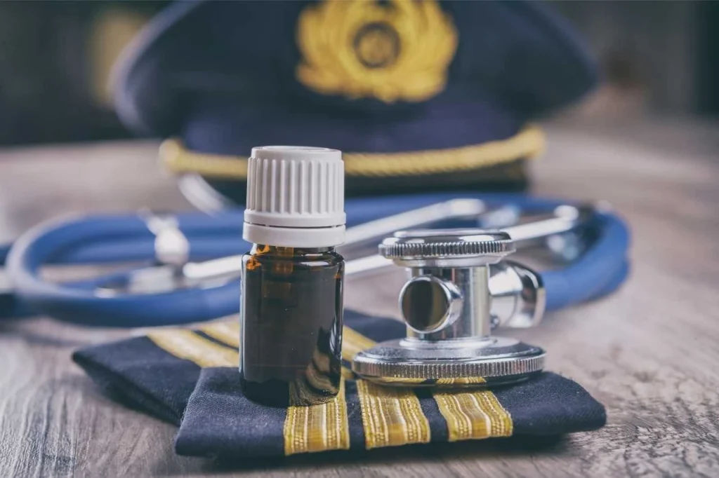 Pilot hat placed beside aviation medical documents, symbolizing health requirements for flight readiness.